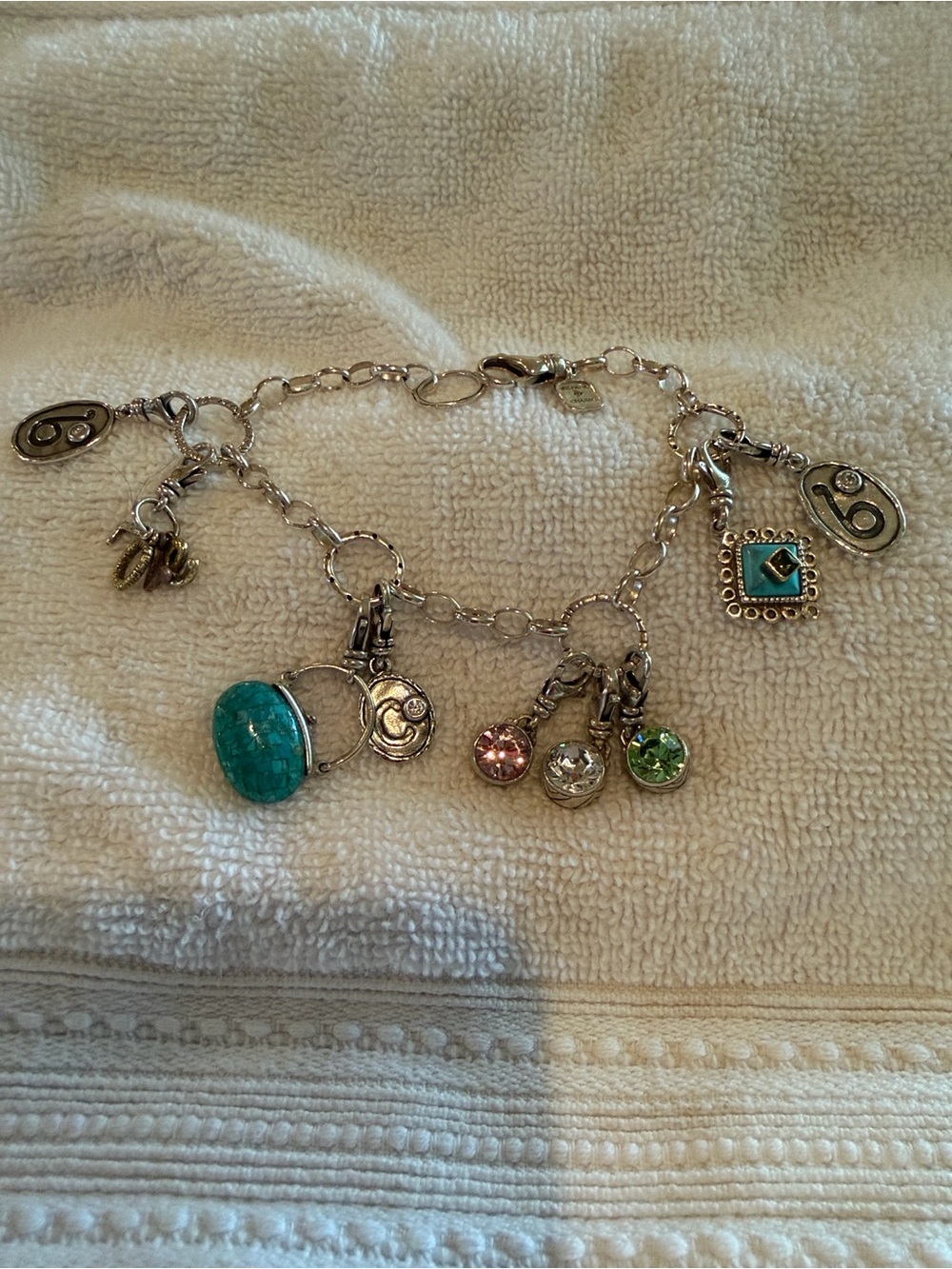 Silpada sterling silver charm bracelet with nine charms.